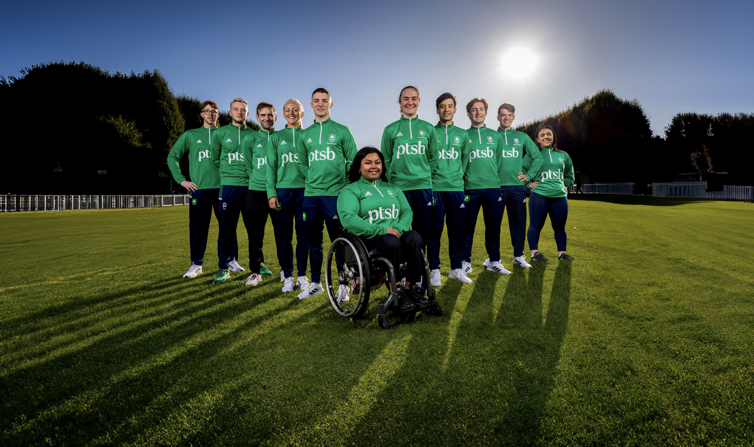 A group photo of Paralympians and Olympians in a field